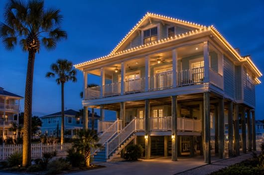 Roofline holiday lighting on a tall elevated stilt beach home in Galveston