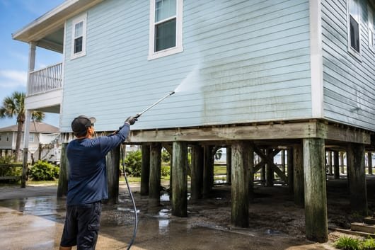 Soft washing the elevated siding of a Galveston stilt beach home